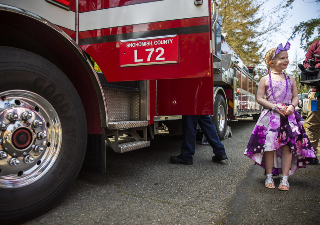 Peyton Vandanacker waits to get into a firetruck to celebrate the end of her chemotherapy treatment on Saturday, April 23, 2022 in Bothell, Washington. (Olivia Vanni / The Herald)
