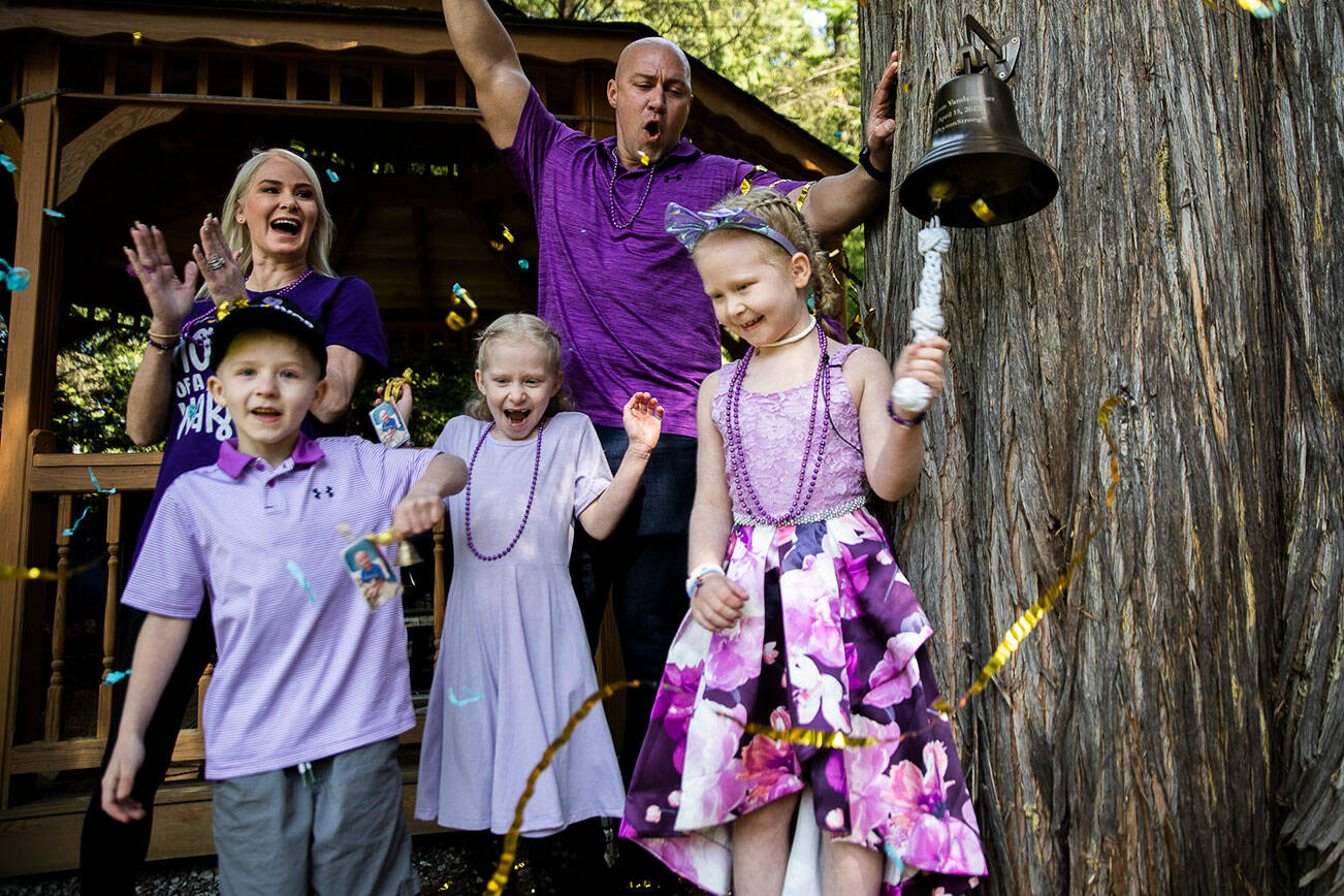 Peyton Vandanacker, 7, rings her bell surrounded by her family in celebration of the end of her chemotherapy treatment for an aggressive type of leukemia on Saturday, April 23, 2022 in Bothell, Washington. (Olivia Vanni / The Herald)