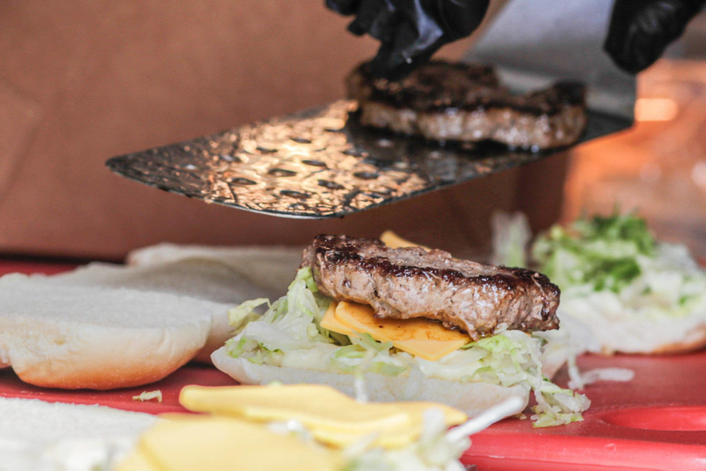 Buddy Burger sliders are dished up Saturday morning in Everett. (Kevin Clark / The Herald)
