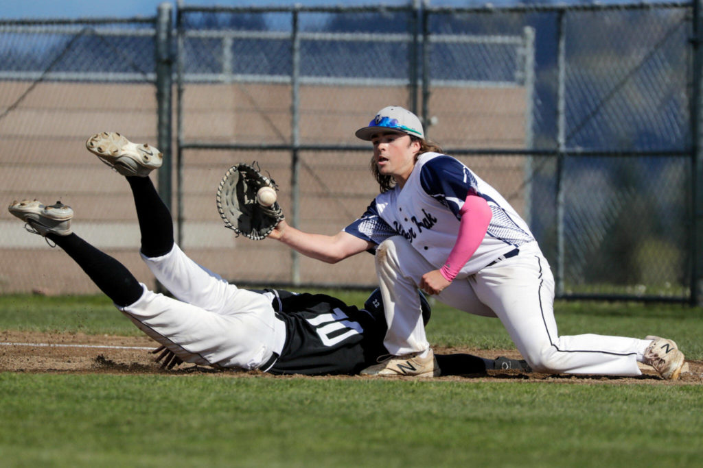 Jackson’s Bryan Ho beats a throw to Glacier Peak’s Colby Holmdahl Friday afternoon at Glacier Peak High School in Snohomish, Washington on April 22, 2022. The Timberwolves won 12-4. (Kevin Clark / The Herald)
