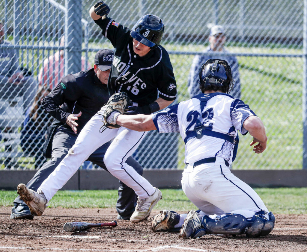 Jackson’s Braden O’Donnell, left, is tagged out by Glacier Peak’s Jacob Erickson Friday afternoon at Glacier Peak High School in Snohomish, Washington on April 22, 2022. The Timberwolves won 12-4. (Kevin Clark / The Herald)
