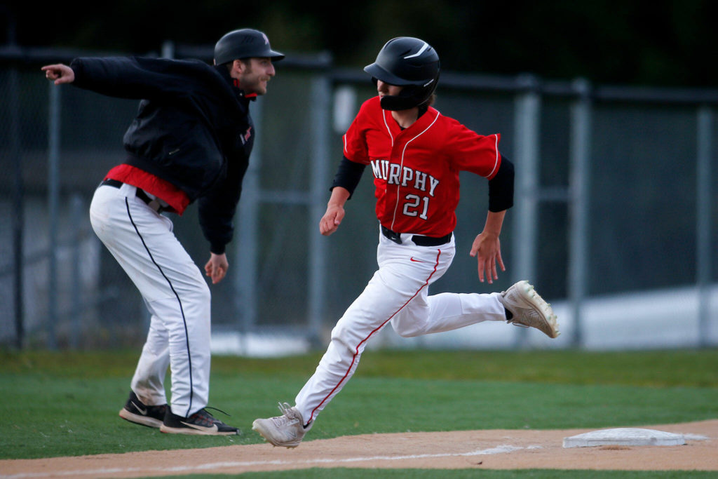 Archbishop Murphy scores a run on a hit against Stanwood Thursday, April 28, 2022, at Archbishop Murphy High School in Everett, Washington. (Ryan Berry / The Herald)

