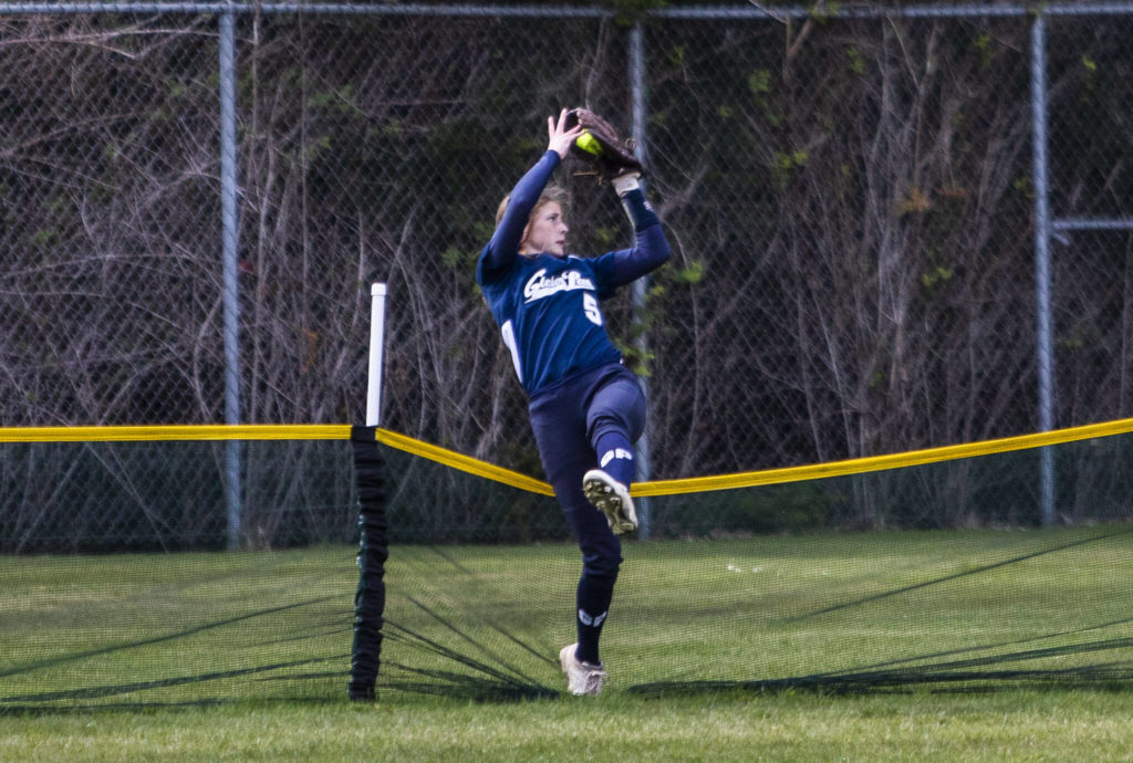 Glacier Peak’s Leyla Carpenter makes a catch over the back barrier during the game against Jackson on Thursday, April 28, 2022 in Everett, Washington. (Olivia Vanni / The Herald)
