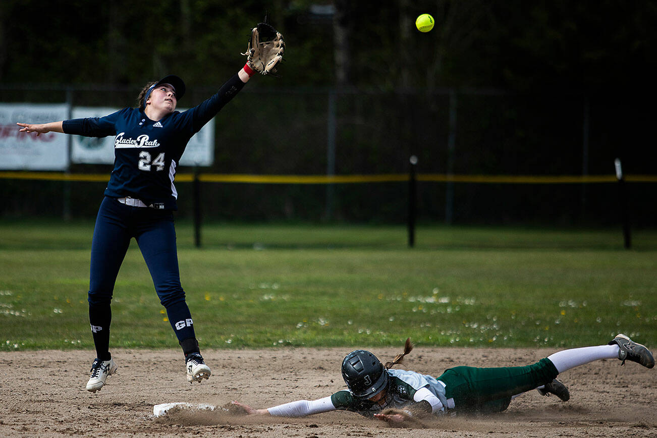 Glacier Peak’s Kaitlyn McCallum reaches for an over thrown ball as Jackson’s Avery Olson slides into second base during the game on Thursday, April 28, 2022 in Everett, Washington. (Olivia Vanni / The Herald)