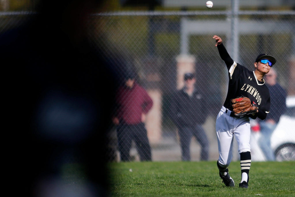 Lynnwood’s Sergio Navarro throws the ball to the cutoff man as a runner scores against Meadowdale Friday, April 29, 2022, at Meadowdale High School in Lynnwood, Washington. (Ryan Berry / The Herald)
