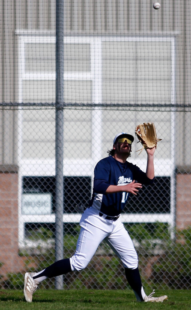 Meadowdale’s Johnathon O’Connell grabs a fly ball to left field against Lynnwood Friday, April 29, 2022, at Meadowdale High School in Lynnwood, Washington. (Ryan Berry / The Herald)
