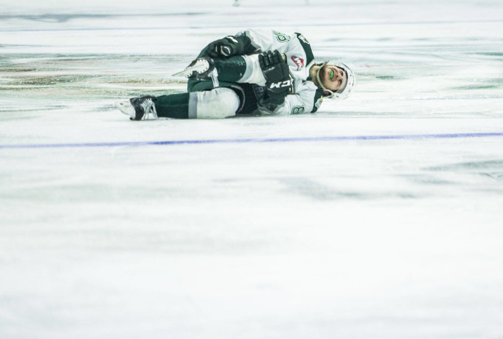 Silvertips’ Niko Huuhtanen rolls on the ice grabbing his leg in pain during the game against the Giants on Saturday, April 30, 2022 in Everett, Washington. (Olivia Vanni / The Herald)
