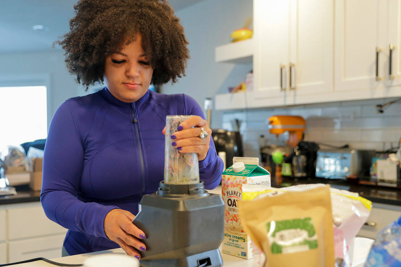 Rainey Forzetting makes a kratom smoothie at her home in Lake Stevens, Washington on March 29, 2022. Blueberries, 6 grams Kratom, a triple berry mix, almond butter, pomegranate and oak milk make up her daily concoction. (Kevin Clark / The Herald)