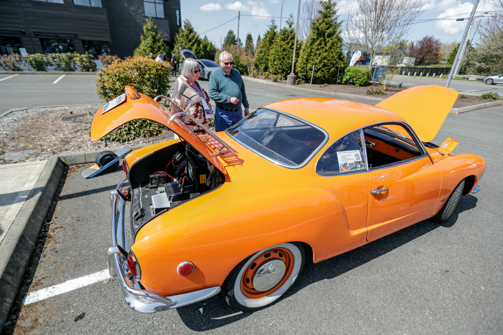 Vicki and Vic Wyant look over a 1969 Volkswagen Karmann Ghia converted from gas to electric by its owners. About 30 electric vehicles were on display at the car show in Mill Creek hosted by Snohomish County Electric Vehicle Association. (Kevin Clark / The Herald)