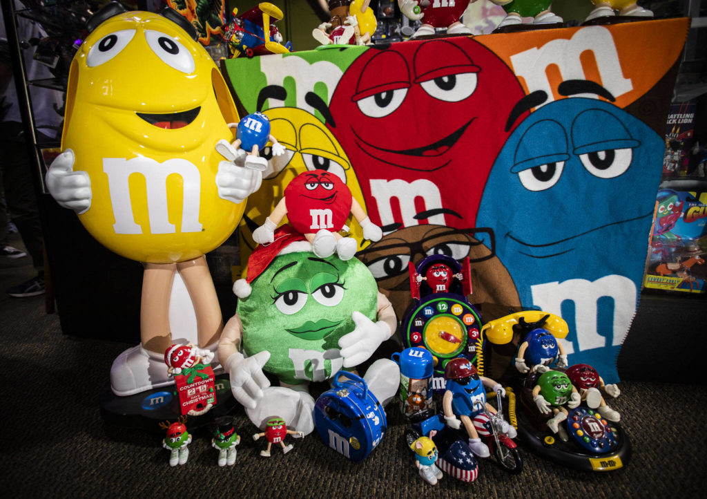 A collection of over 100 M&M’s memorabilia items will be for sale at BobaKhan Toys in Everett on Saturday in memory of Maria Moore, who was 9 when she died in 2015. Her brother T.J., 14, collected M&M’s items and donated the collection to raise money for Seattle Children’s cancer programs. (Olivia Vanni / The Herald)
