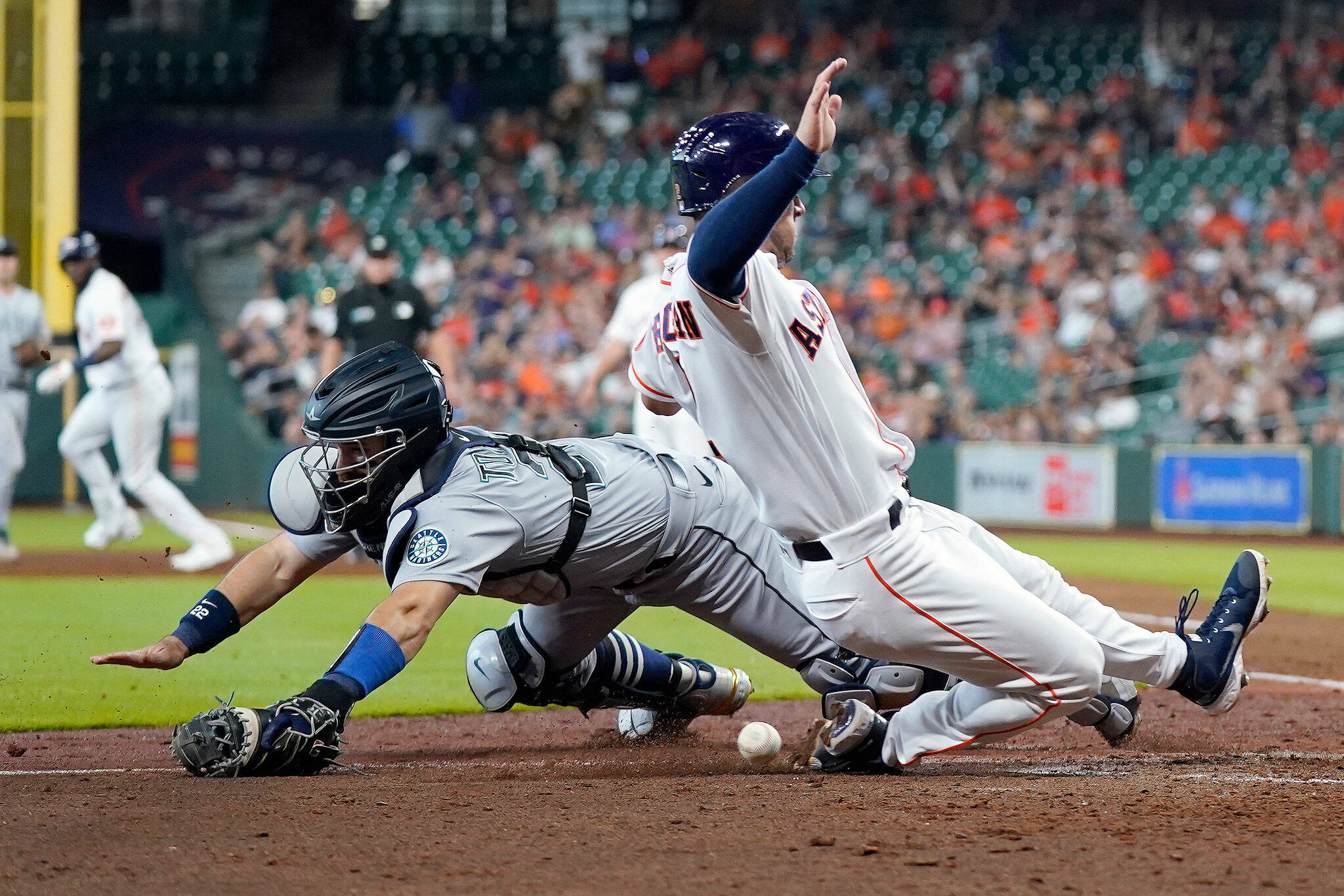 Mariners catcher Luis Torrens (left) reaches for the ball as the Astros’ Alex Bregman scores during the sixth inning of a game Wednesday in Houston. (AP Photo/David J. Phillip)