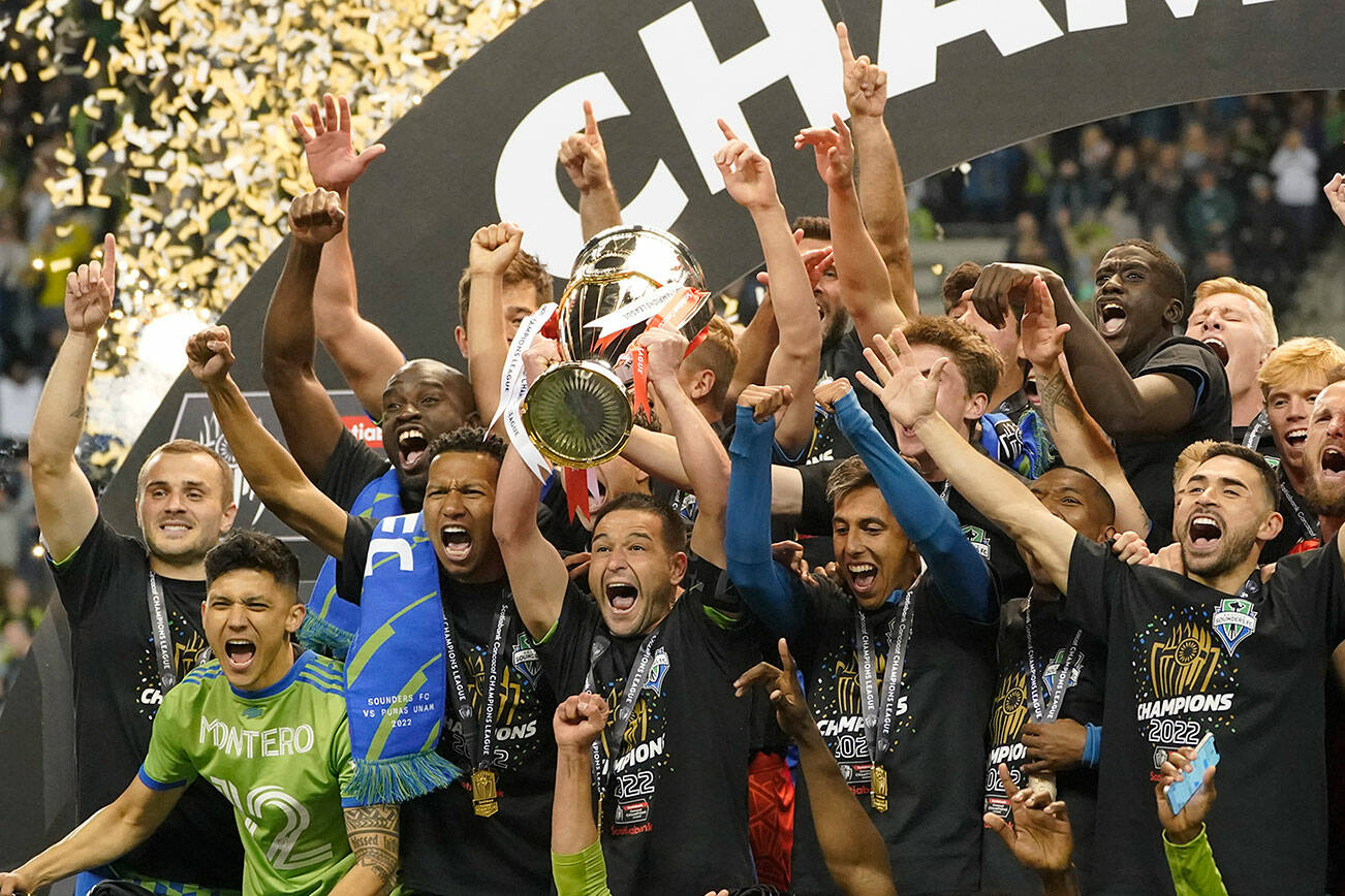 United States' Seattle Sounders midfielder Nicolas Lodeiro holds the trophy alongside teammates after defeating Mexico's Pumas to win the CONCACAF Champions League soccer final Wednesday, May 4, 2022, in Seattle. (AP Photo/Ted S. Warren)