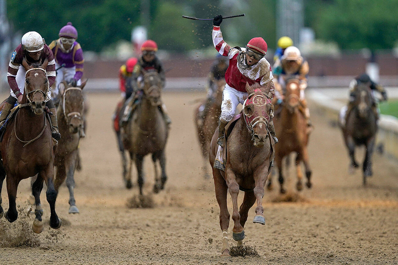 Sonny Leon celebrates after riding Rich Strike past the finish line to win the 148th running of the Kentucky Derby horse race at Churchill Downs Saturday, May 7, 2022, in Louisville, Ky. (AP Photo/Charlie Neibergall)