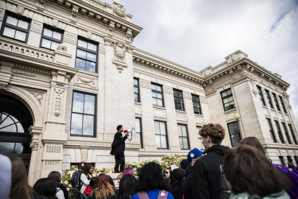 Everett High School student Soren Dellaguardia speaks to a group of students before leading a walkout to North Middle School on Monday in Everett. (Olivia Vanni / The Herald)
