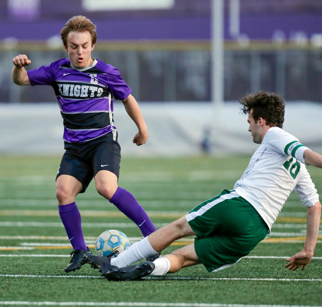 Kamiak’s Aidan Drought has the ball kicked loose by Skyline’s Charles Gall during a winner-to-state bi-district semfinal game Tuesday evening at Kamiak High School in Mukilteo. (Kevin Clark / The Herald)
