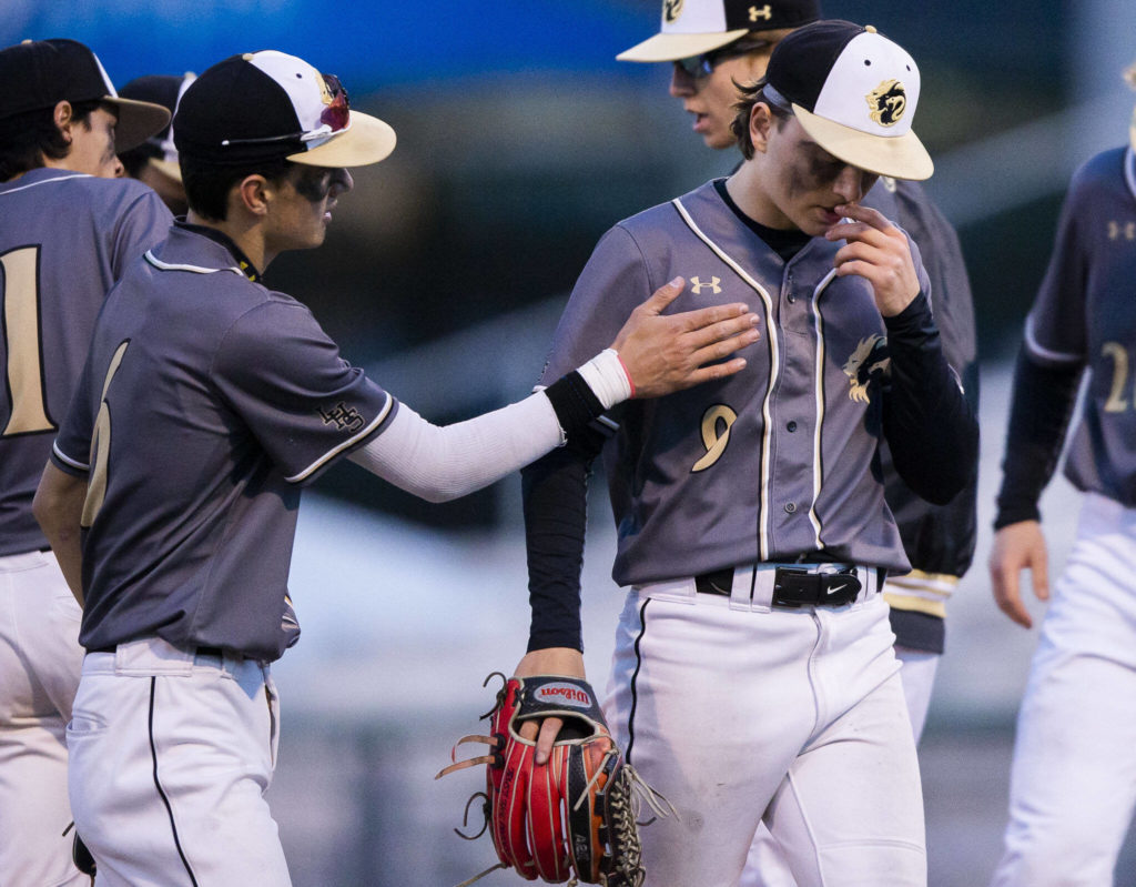Lynnwood’s Keenan Masters is patted by a teammate after being pulled from pitching during the district semifinal game at Funko Field on Tuesday in Everett. (Olivia Vanni / The Herald)
