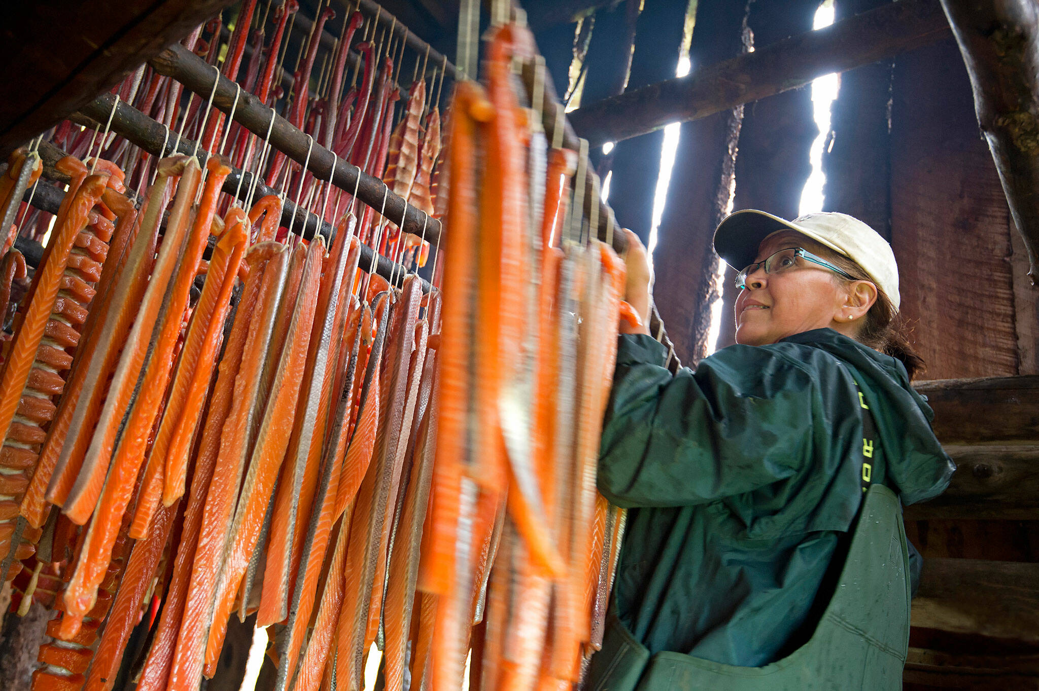 Shelly Leary prepares salmon for smoking in Napaimute, Alaksa. “I was taught to always be ready, to have food for the winter. When the smokehouse is filled, I feel good because I know I have enough,” Leary said. (Amy Gulick)