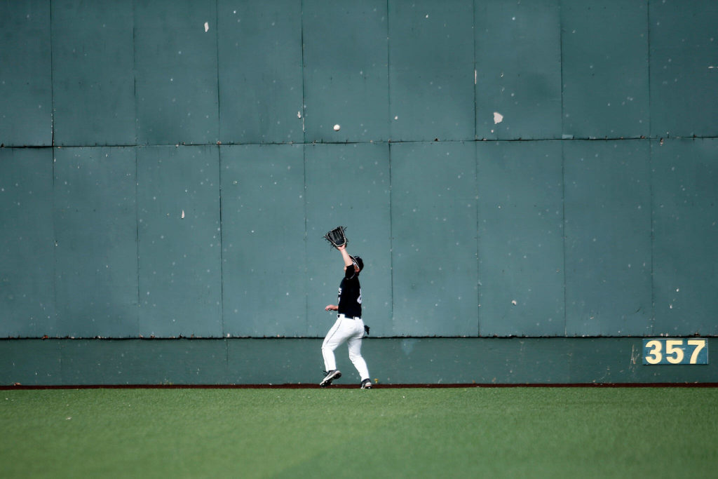 Jackson’s Hunter Komine tracks a deep fly ball to the wall against Bothell Friday, May 13, 2022, at Funko Field in Everett, Washington. (Ryan Berry / The Herald)
