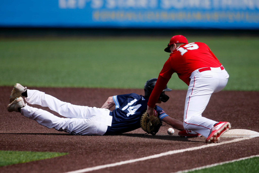 Meadowdale’s Broderick Bluhm gets his hand back to the bag on a throw to first against Stanwood Saturday, May 14, 2022, during a 3A district matchup at Funko Field in Everett, Washington. (Ryan Berry / The Herald)
