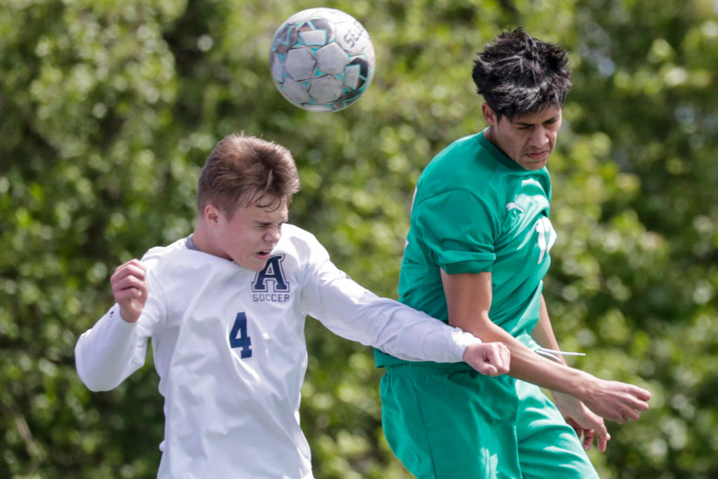 Arlington’s Bjorn Gudgeon, left, and Edmonds-Woodway’s Victor Ibarra jump for a header Saturday afternoon at Shoreline Stadium in Shoreline, Washington on May 14, 2022. The Warriors won 4-2. (Kevin Clark / The Herald)
