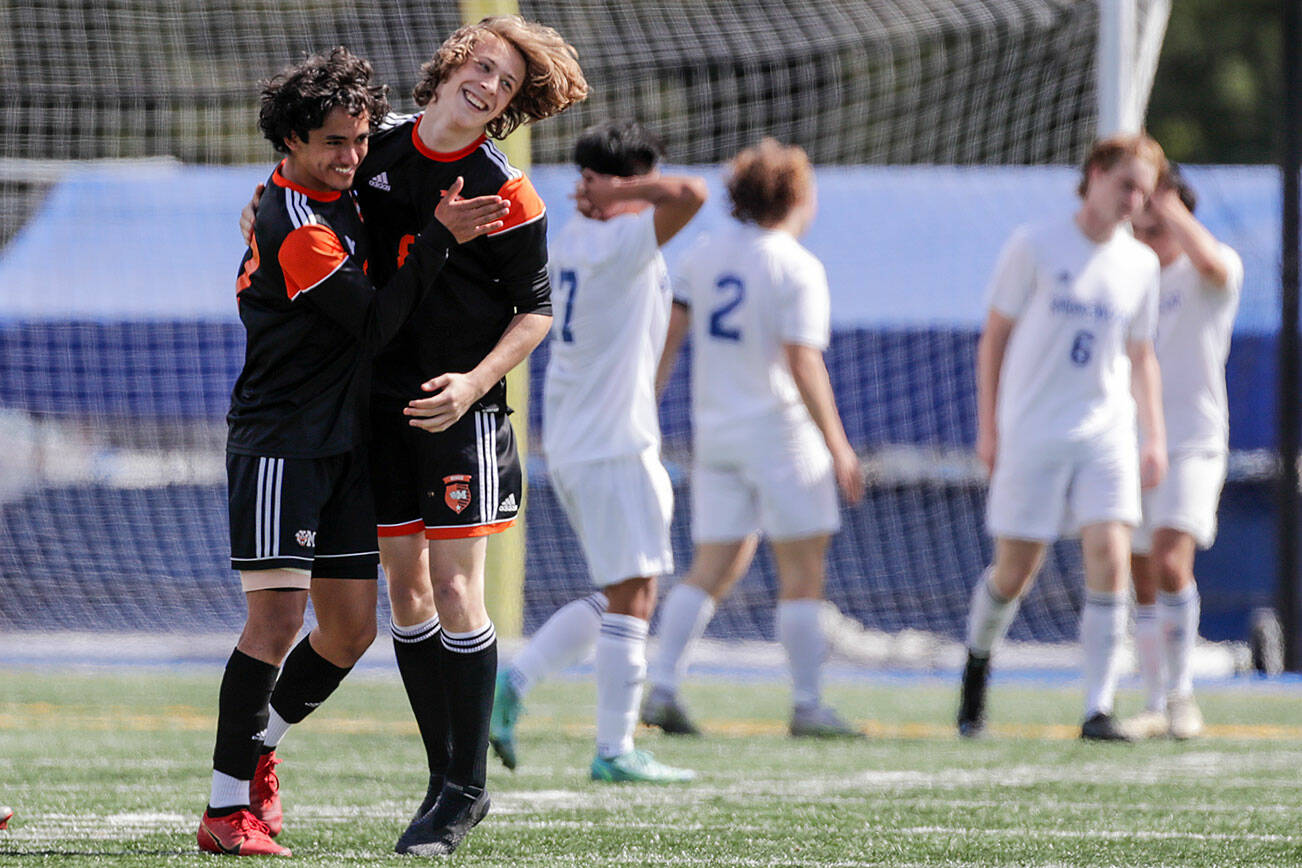 Monroe’s Diego Perez-Diaz, left, and Tanner Summers celebrate their win over Shorewood Saturday afternoon at Shoreline Stadium in Shoreline, Washington on May 14, 2022.  The Bearcats won 2-0. (Kevin Clark / The Herald)