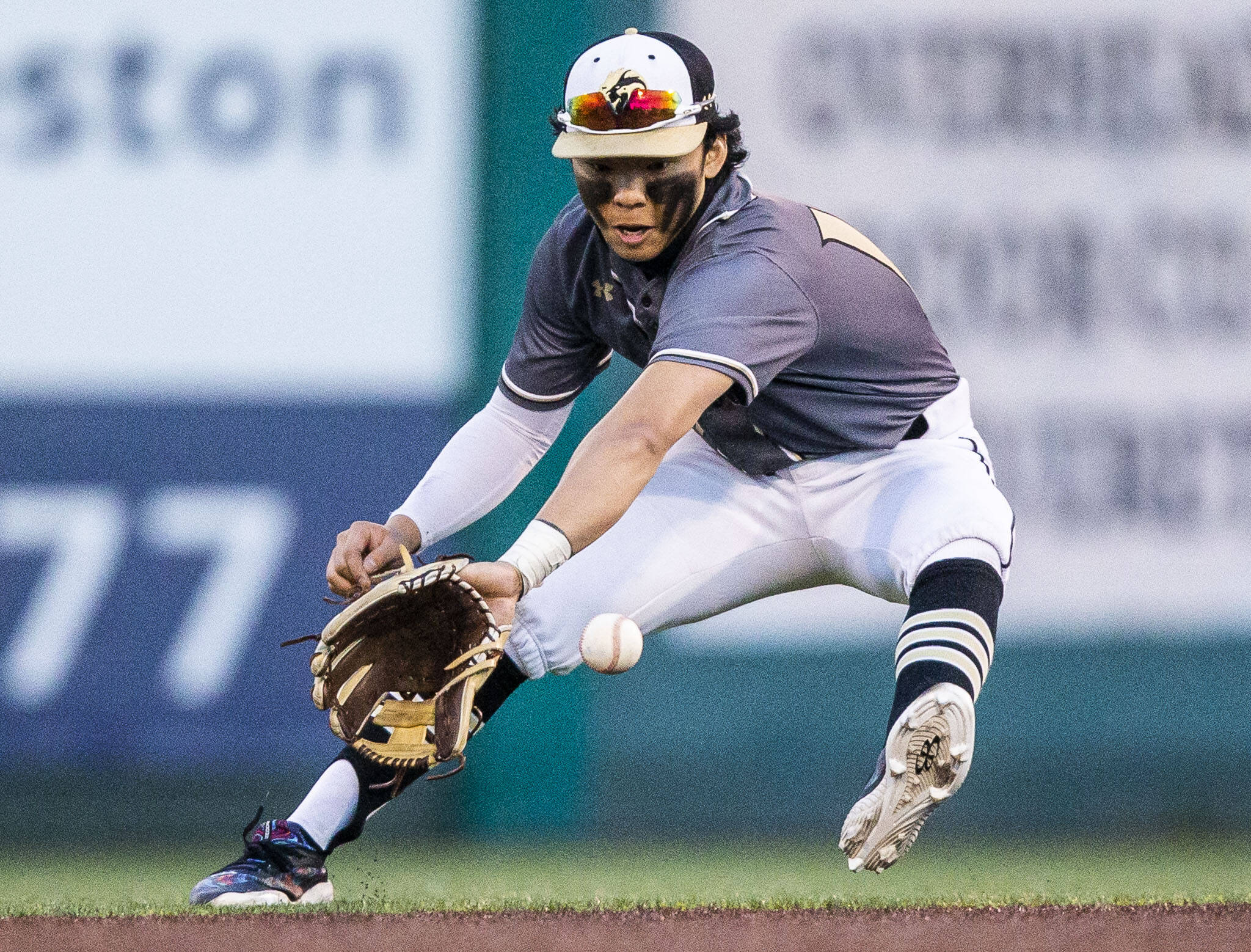 Lynnwood’s Leyon Camantigue stops a ground ball hit past second base during the district semifinal game at Funko Field on Tuesday, May 10, 2022 in Everett, Washington. (Olivia Vanni / The Herald)