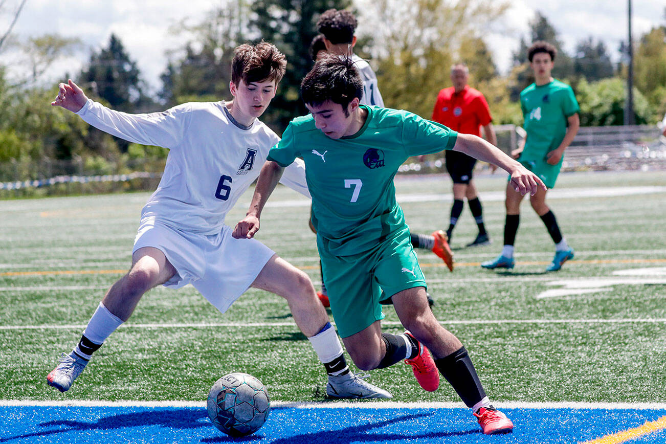 Arlington's Tyler Howe, left, and Edmonds-Woodway's Ryan Hanby vie for control of the ball Saturday afternoon at Shoreline Stadium in Shoreline, Washington on May 14, 2022.  The Warriors won 4-2. (Kevin Clark / The Herald)
