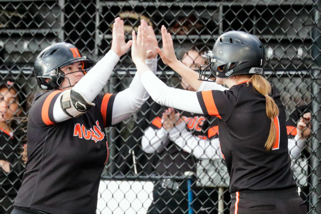 Anniston Oylear (left) high-fives teammate River Mahler. (Kevin Clark / The Herald)
