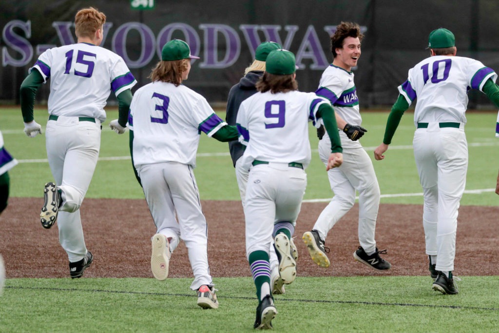 Edmonds-Woodway players rush toward teammate Jack Beers (facing) after he drove in the game-winning run. (Kevin Clark / The Herald)
