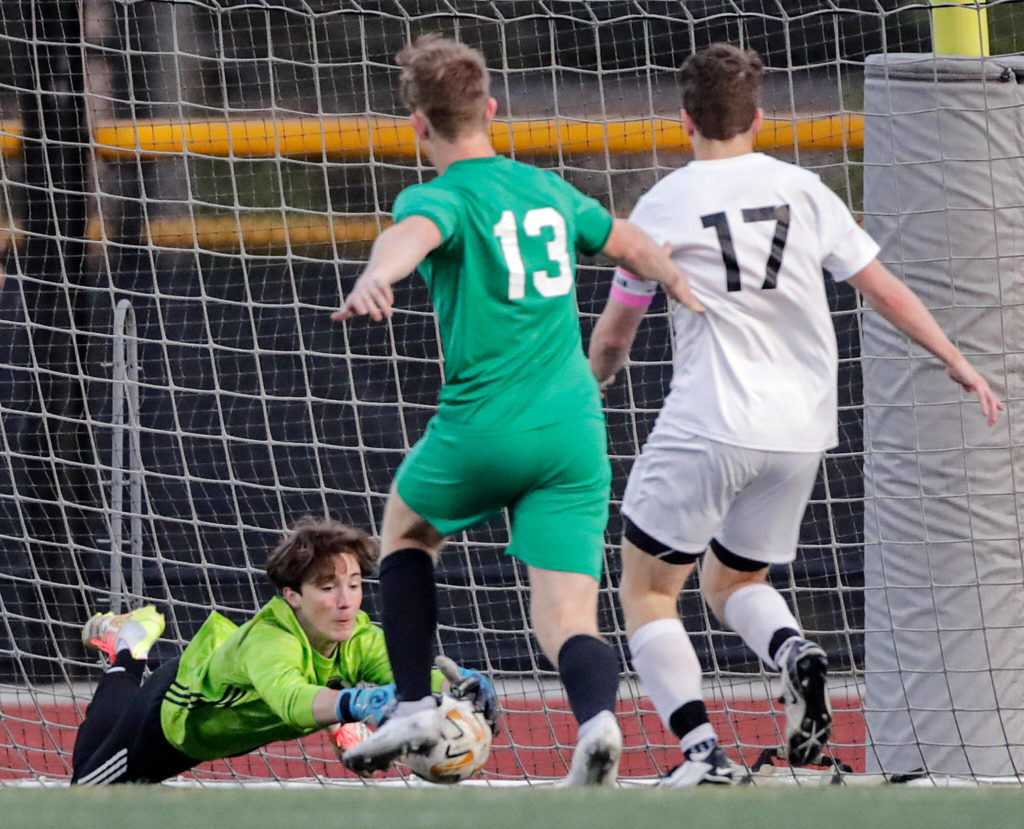 Edmonds-Woodway’s Gabe Wilhelm jumps on a shot at goal with Edmonds-Woodway’s Phillip Borchert (center) and Bonney Lake’s Connor Goff closing Tuesday at Edmonds-Woodway High School. (Kevin Clark / The Herald)
