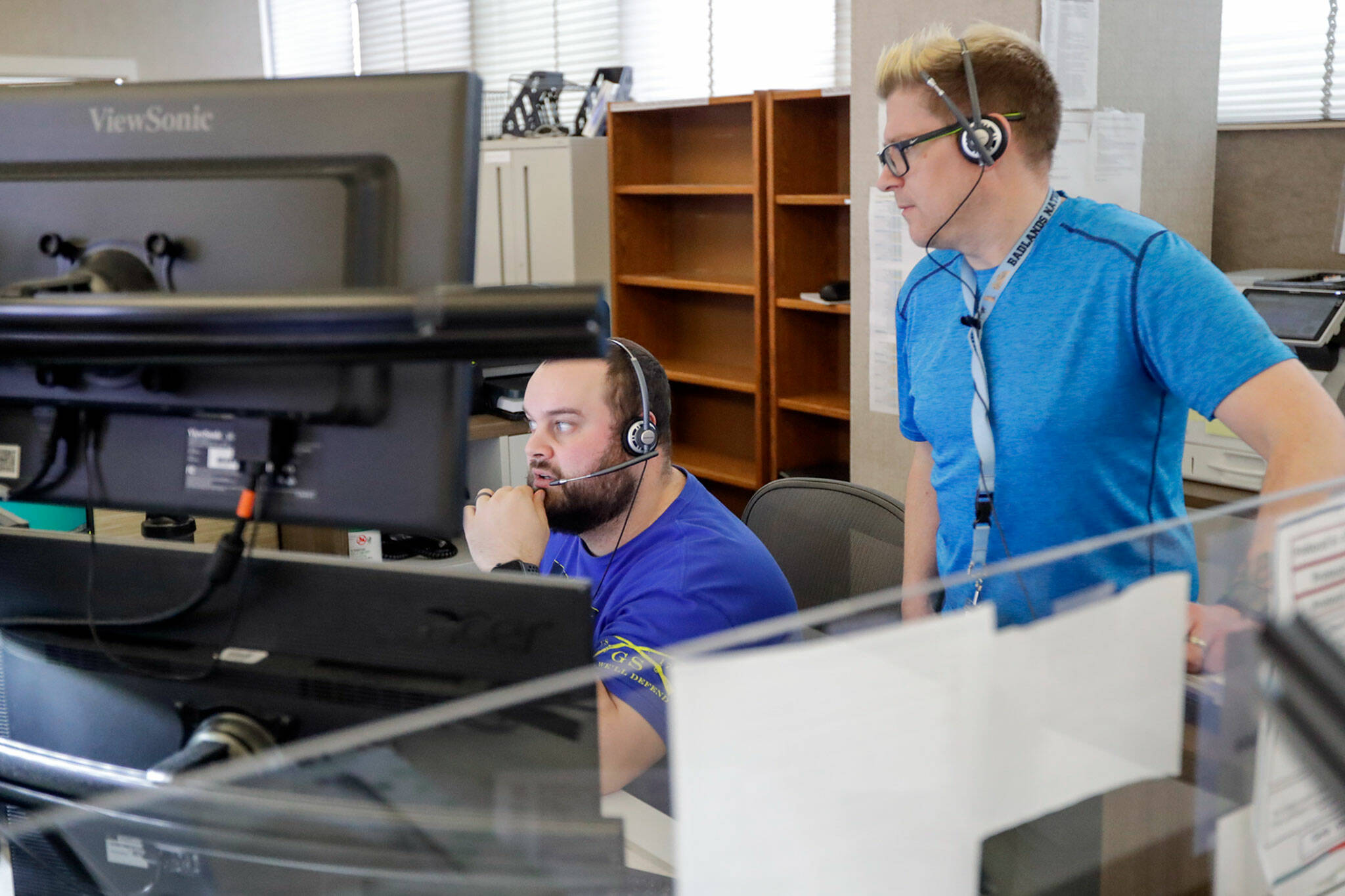 Wade Brickman works through a call with trainer Lars Coleman on Friday afternoon at SNO911 in Everett. (Kevin Clark / The Herald)