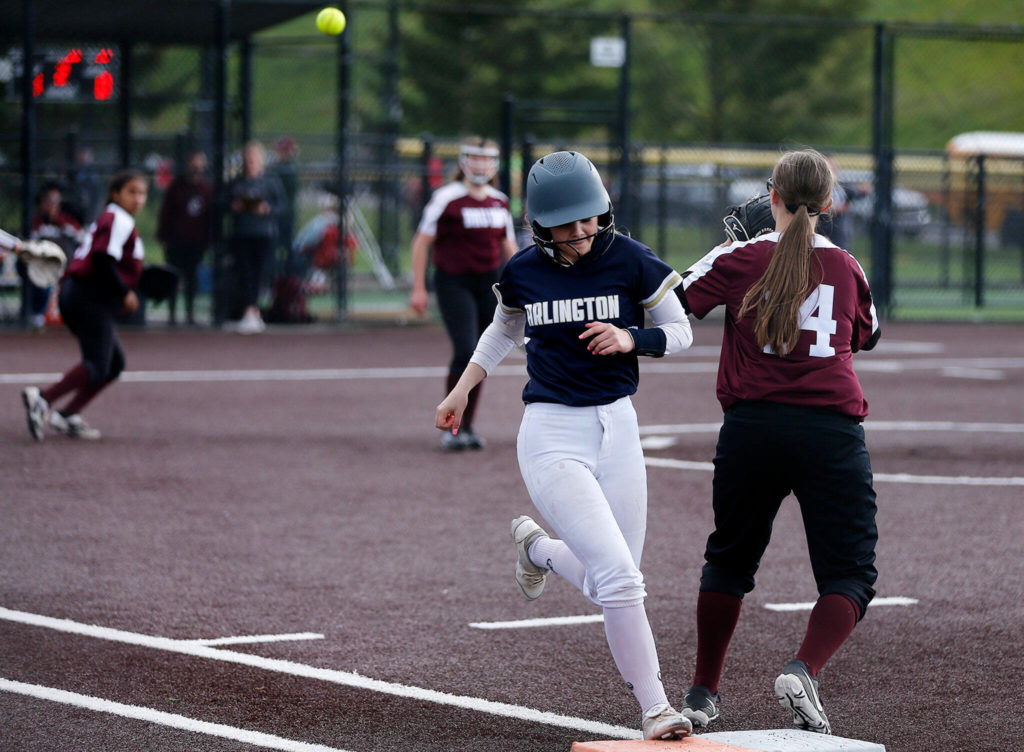 Arlington’s Avery Zodrow beats the throw on a bunt hit against Cascade during Tuesday’s Class 3A District 1 matchup at the Phil Johnson Ballfields in Everett. (Ryan Berry / The Herald)
