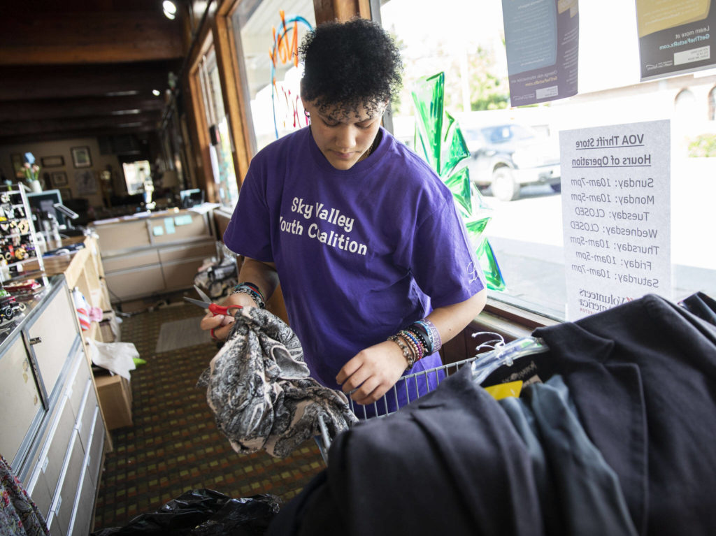 Destiny Conner, 13, takes tags off of clothing at the new Volunteers for America storefront on May 16 in Sultan. (Olivia Vanni / The Herald)
