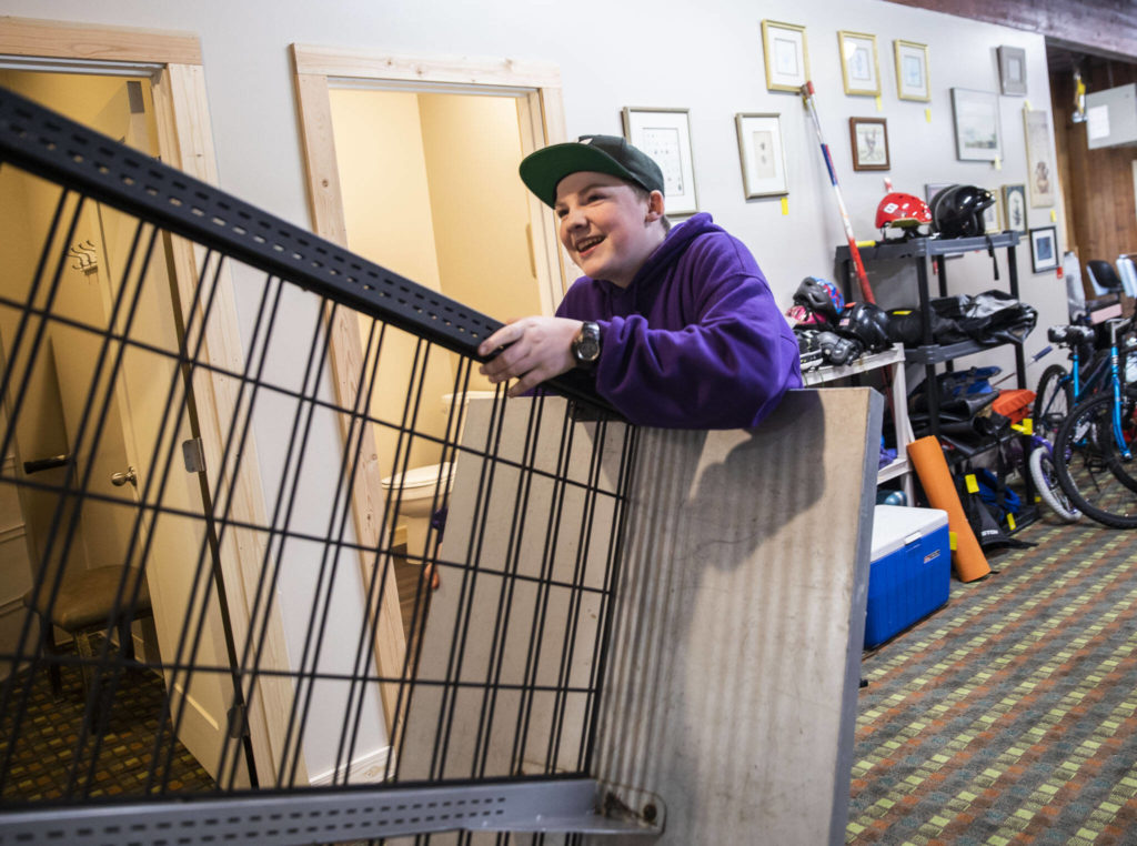 James Nelson, 14, moves a clothing rack at the new Volunteers for America storefront on May 16 in Sultan. (Olivia Vanni / The Herald)
