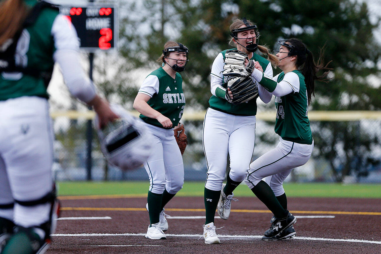 Skyline’s Ryan Grace is swarmed by teammates after striking out a batter to complete a 10-inning complete game win against Jackson Wednesday, May 18, 2022, during a Class 4A matchup at the Phil Johnson Ballfields in Everett, Washington. (Ryan Berry / The Herald)