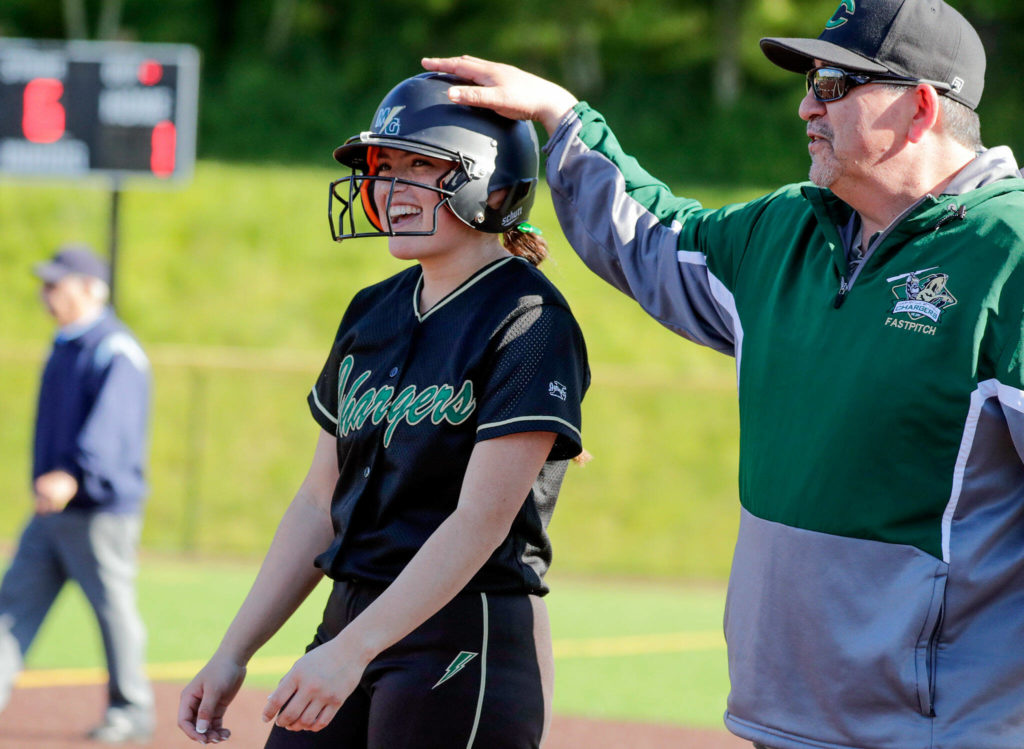 Marysviile-Getchell’s Morgan Epperson is all laughs after a base hit with assist coach Jamie Bombach against Everett High School at Phil Johnson Ball Field in Everett, Washington on May 19, 2022.(Kevin Clark / The Herald)
