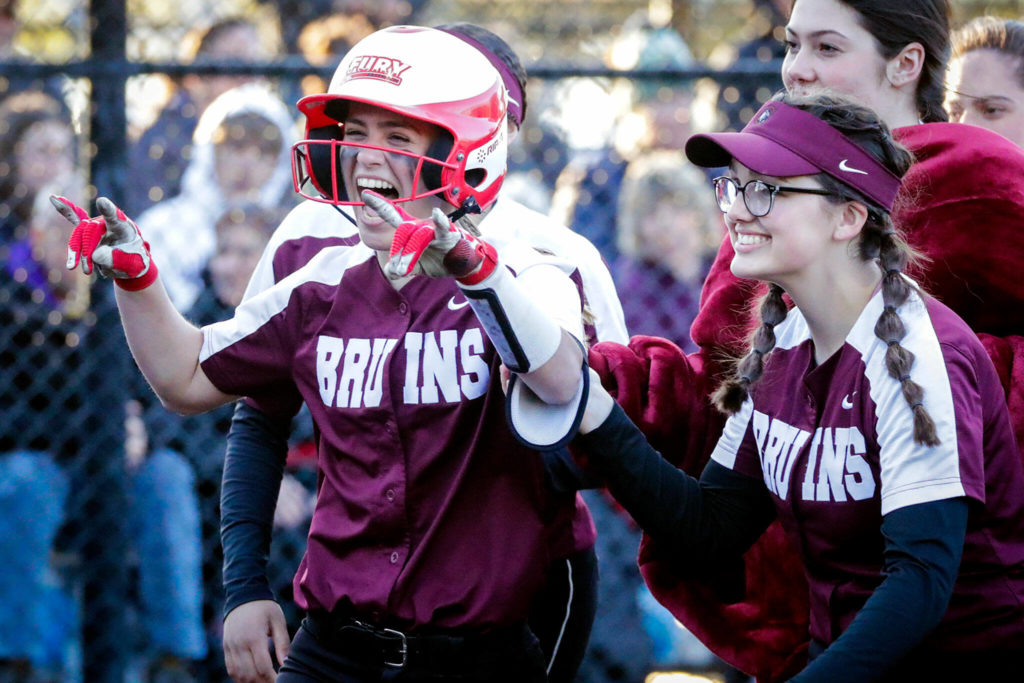 Cascade junior Ashlyee Bloch (left) celebrates her solo home run. The Bruins blasted seven homers in their title-game romp. (Kevin Clark / The Herald)
