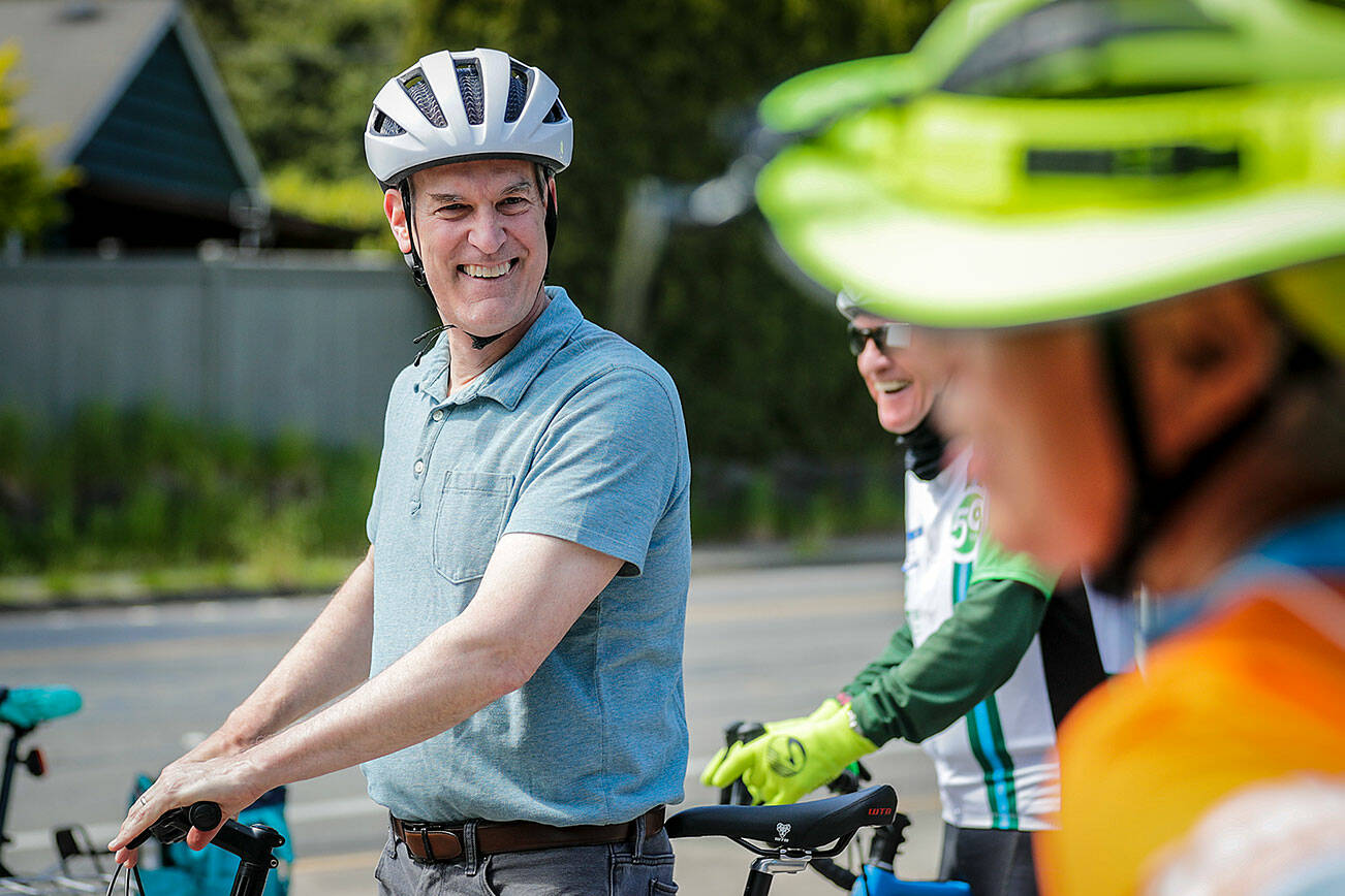 Rep. Rick Larsen shares a laugh during a bike tour of the Interurban Trail through Mountlake Terrace and Edmonds, Washington on May 23, 2022.  (Kevin Clark / The Herald)