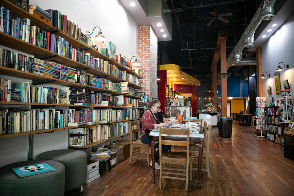 Judi Ramsey, owner of Artisans Mercantile, works at a table at her store. (Ryan Berry / The Herald)
