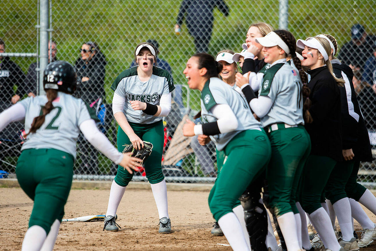 Jackson players surround the plate to congratulate teammate Kaila Zellmer for hitting a home run during the game against Glacier Peak on Thursday, April 28, 2022 in Everett, Washington. (Olivia Vanni / The Herald)