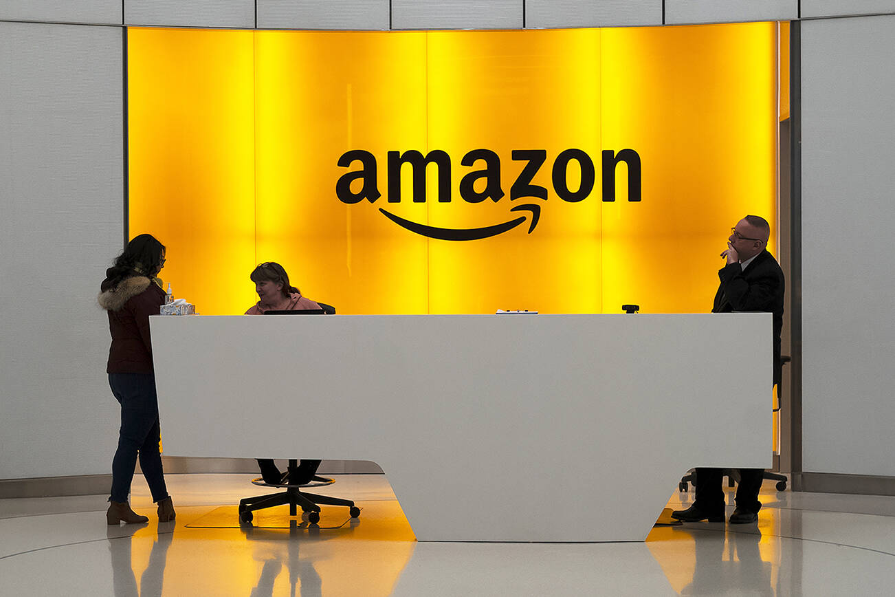 FILE - In this Feb. 14, 2019, file photo, people stand in the lobby for Amazon offices in New York. Amazon shareholders on Wednesday, May 25, 2022 voted down a proposal calling for an independent audit of working conditions at the e-commerce behemoth's warehouses. (AP Photo/Mark Lennihan, File)