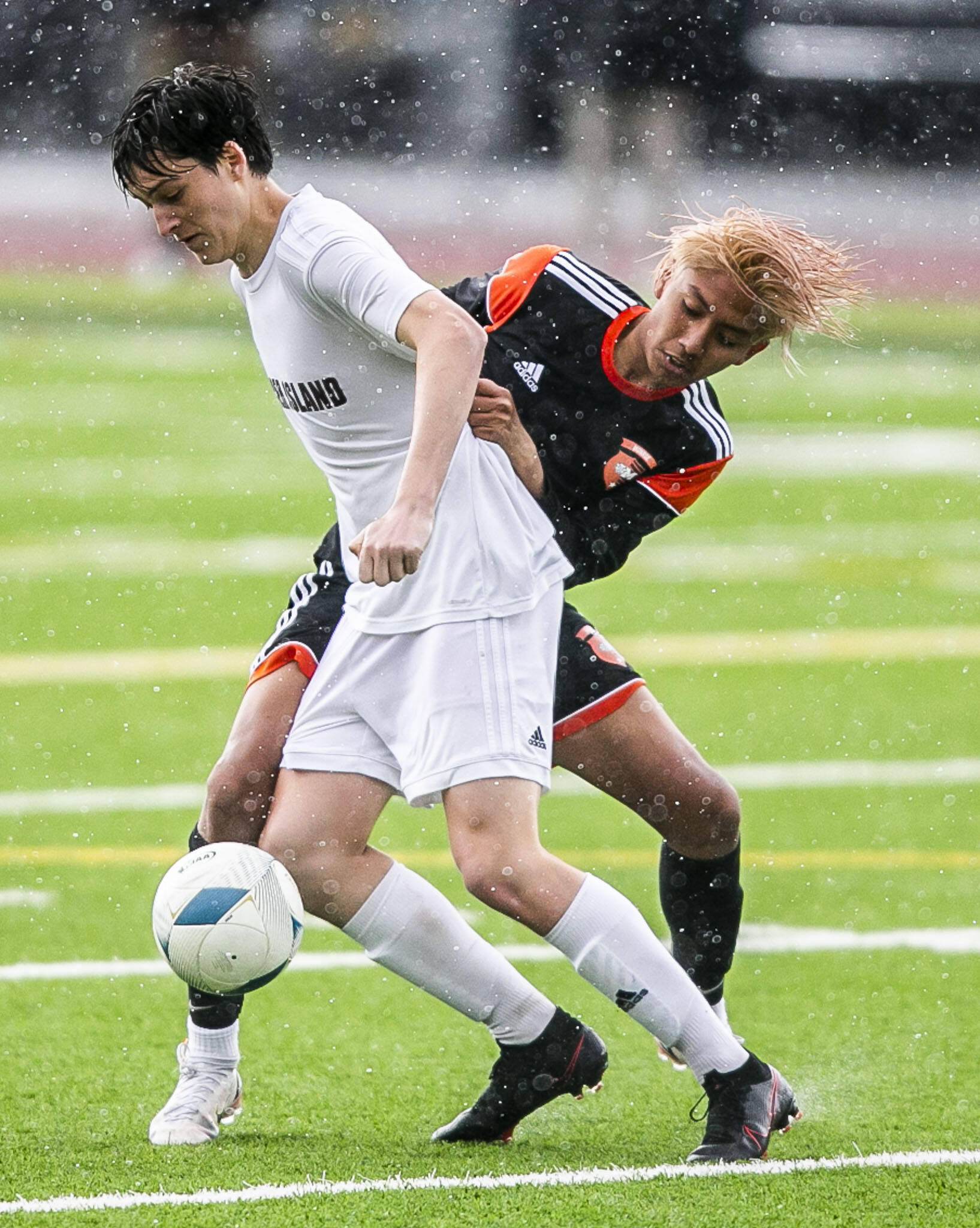 Monroe’s Brayan Ojeda-Gaspar battles Mercer Island’s Leo Berkley for the ball during the 3A boys state semifinal on Friday, May 27, 2022 in Puyallup, Washington. (Olivia Vanni / The Herald)