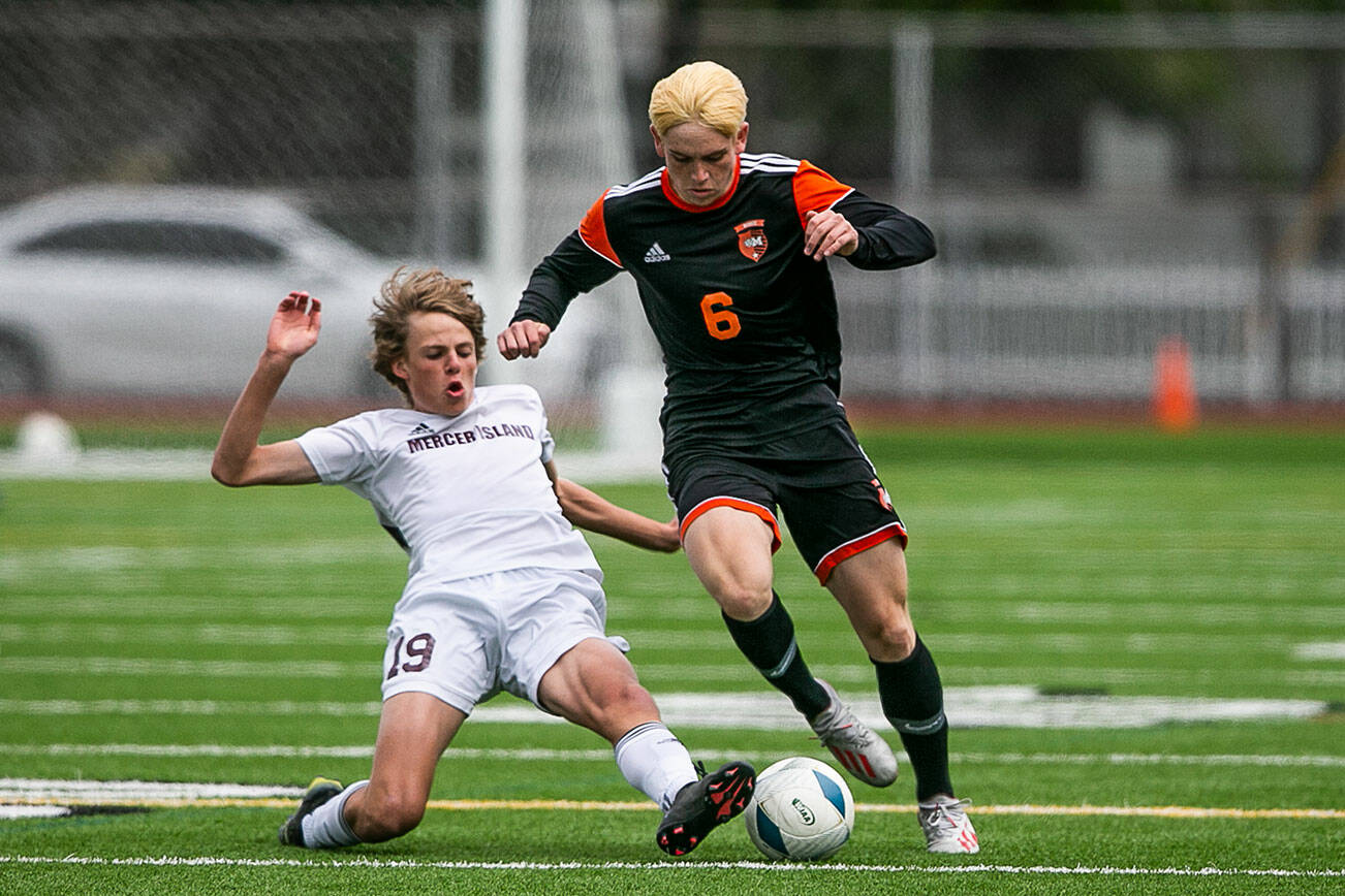Monroe’s Owen Skurdal is slide tackled by Mercer Island’s Edward Brown during the 3A boys state semifinal on Friday, May 27, 2022 in Puyallup, Washington. (Olivia Vanni / The Herald)