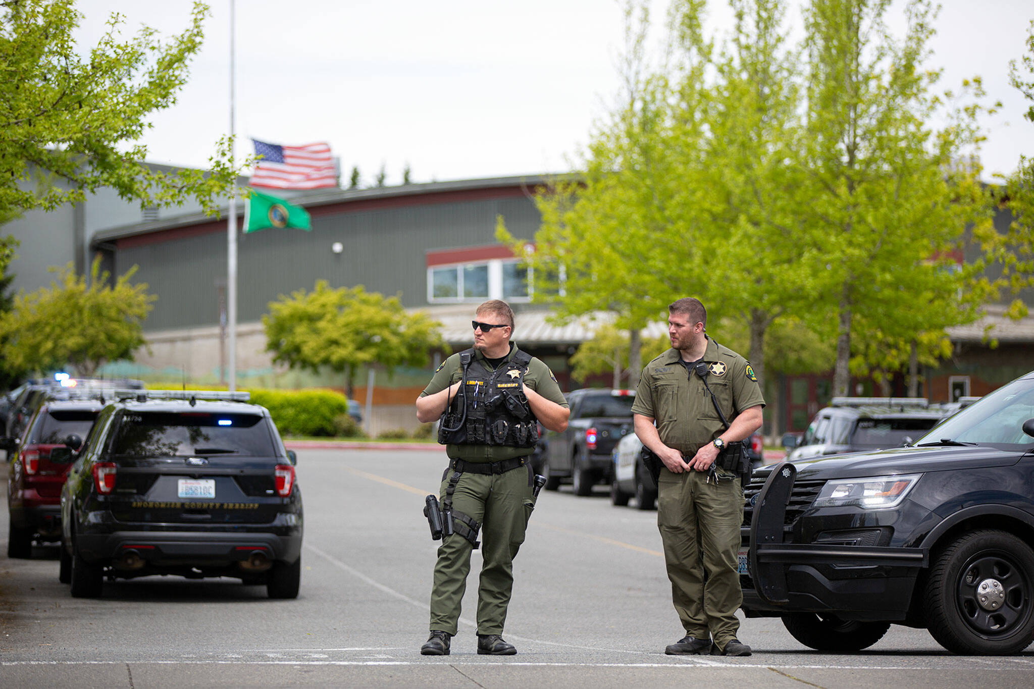 Law enforcement officers stand guard at the front driveway to Cascade High School after a reported of a firearm near campus Friday in Everett. (Ryan Berry / The Herald)