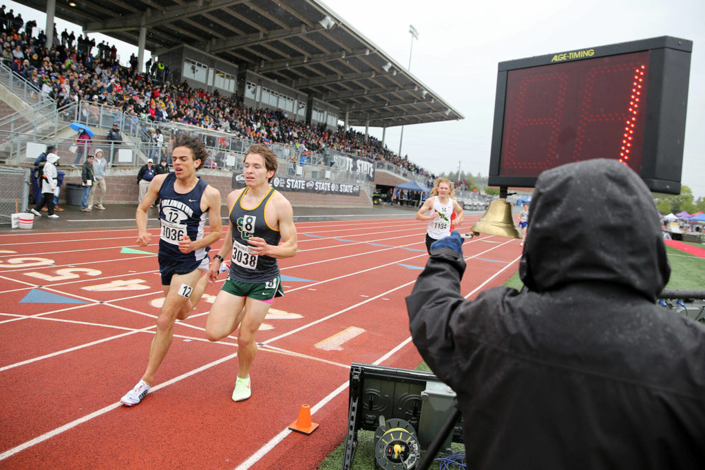 Arlington’s Brandon Moore, left, heads into the final lap of the 3A boys 3200 Saturday, May 28, 2022, at the 2022 WIAA State Track & Field Championships at Mount Tahoma High School in Tacoma, Washington. (Ryan Berry / The Herald)
