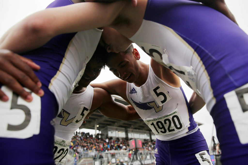 The Lake Stevens boys 4×400 relay team huddle up after finishing first in their race, securing an overall state title Saturday, May 28, 2022, at the 2022 WIAA State Track & Field Championships at Mount Tahoma High School in Tacoma, Washington. (Ryan Berry / The Herald)
