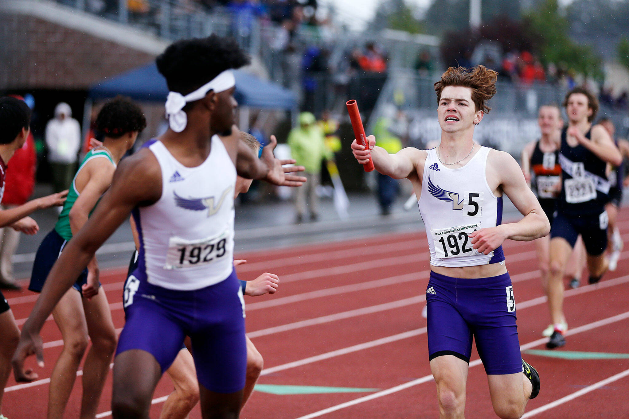 Lake Stevens’ Kaden Chidester hands off the baton to teammate Hamid Sylla during the 4A boys 4x400 relay Saturday, May 28, 2022, at the 2022 WIAA State Track & Field Championships at Mount Tahoma High School in Tacoma, Washington. (Ryan Berry / The Herald)