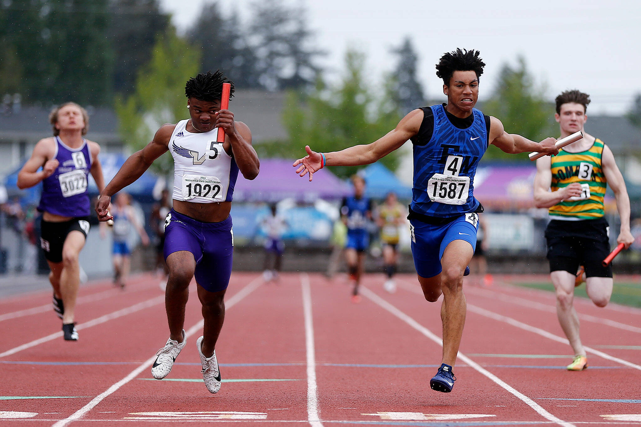 Lake Stevens’ Trayce Hanks, left, finishes off his team’s win in the 4A boys 4X100 relay Saturday, May 28, 2022, at the 2022 WIAA State Track & Field Championships at Mount Tahoma High School in Tacoma, Washington. (Ryan Berry / The Herald)