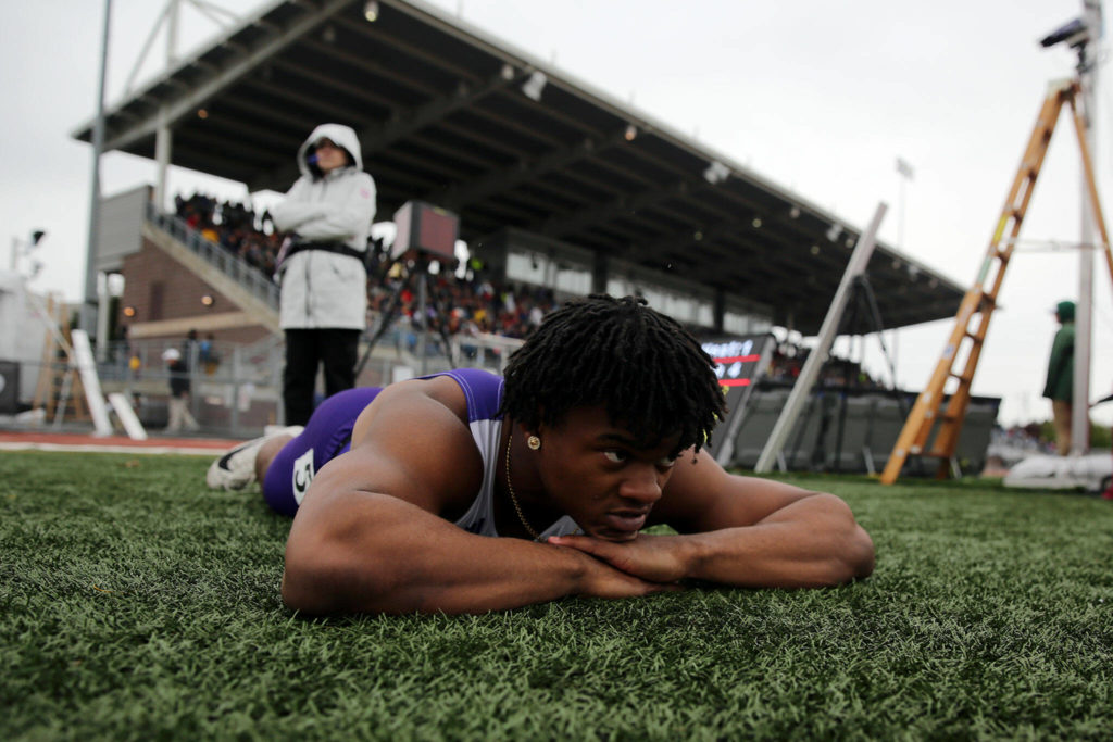 Lake Stevens’ Trayce Hanks lies on the ground after losing the 100 meter dash by less than one hundredth of a second Saturday, May 28, 2022, at the 2022 WIAA State Track & Field Championships at Mount Tahoma High School in Tacoma, Washington. (Ryan Berry / The Herald)
