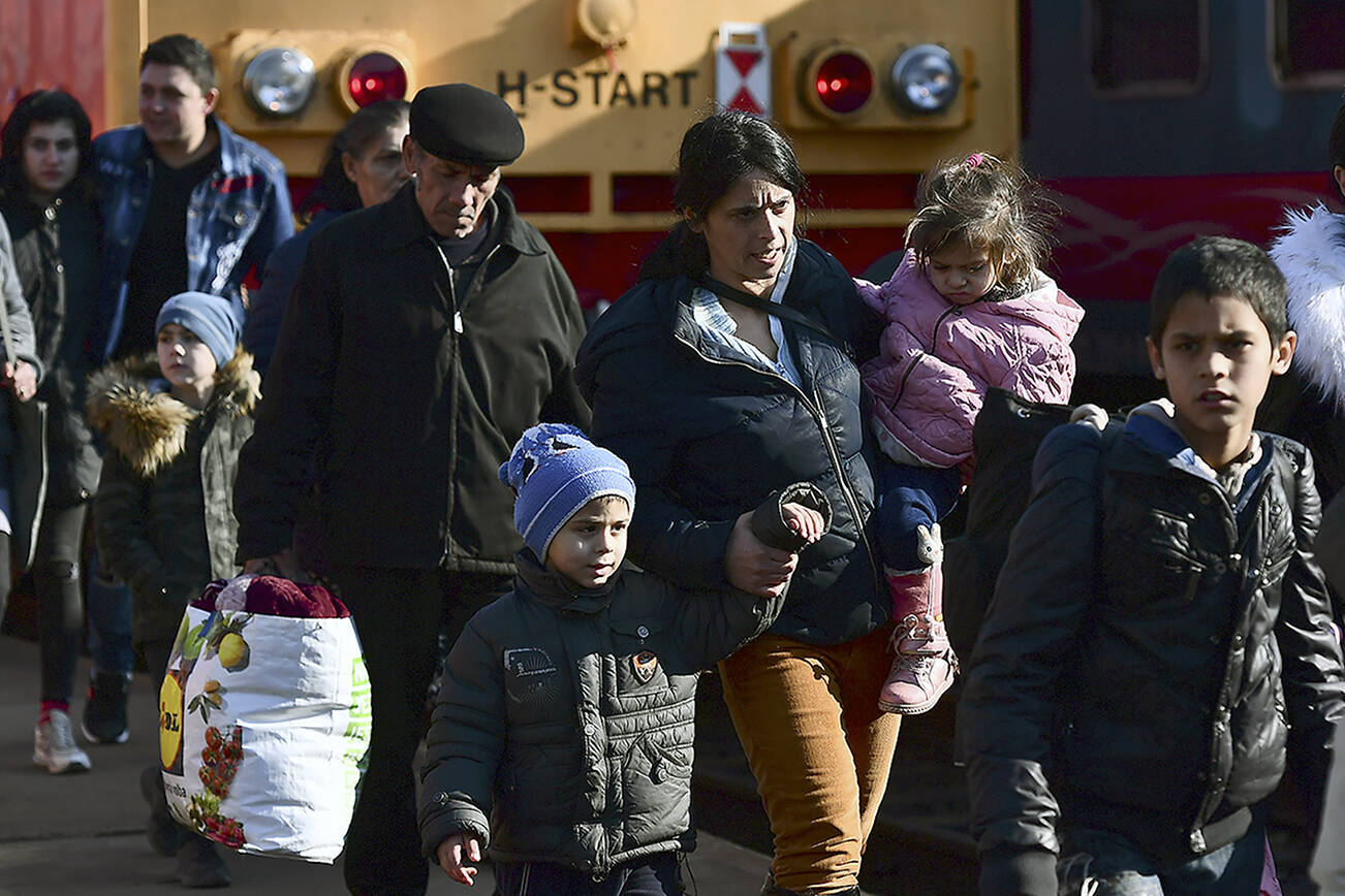 FILE - Refugees fleeing conflict from neighboring Ukraine arrive to Zahony, Hungary, Sunday, Feb. 27, 2022. As hundreds of thousands of Ukrainians seek refuge in neighboring countries, cradling children in one arm and clutching belongings in the other, leaders in Poland, Hungary, Bulgaria, Moldova and Romania are offering a hearty welcome. (AP Photo/Anna Szilagyi, File)